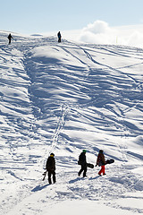 Image showing Snowboarders on footpath in snow at sun morning