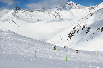 Image showing Skier and snowboarder downhill on freeride trace and mountains i