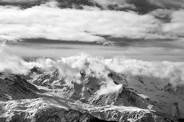 Image showing Black and white snow mountains in sunlight clouds