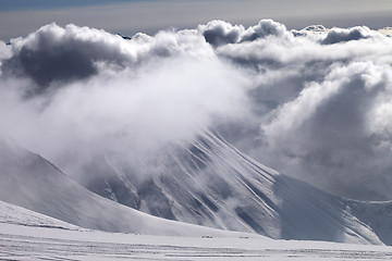 Image showing Ski slope and mountains in sunlight storm clouds before snowfall