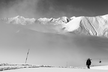 Image showing Black and white view on off-piste slope with snowboarder and mou