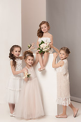 Image showing Little pretty girls with flowers dressed in wedding dresses