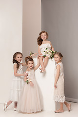 Image showing Little pretty girls with flowers dressed in wedding dresses