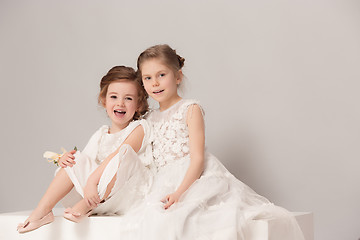 Image showing Little pretty girls with flowers dressed in wedding dresses