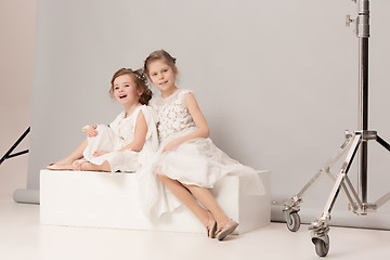 Image showing Little pretty girls with flowers dressed in wedding dresses