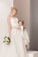 Image showing Little pretty girls with flowers dressed in wedding dresses