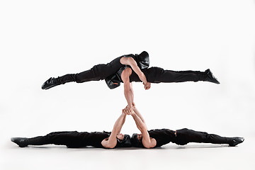 Image showing The group of gymnastic acrobatic caucasian men on balance pose