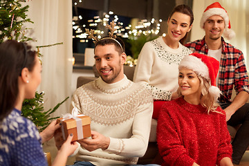 Image showing friends celebrating christmas and giving presents