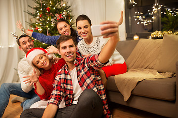 Image showing friends celebrating christmas and taking selfie