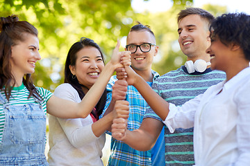 Image showing happy friends making thumbs up in park