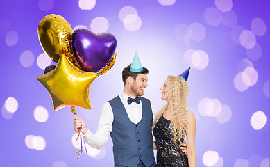 Image showing happy couple with party caps and balloons