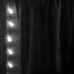 Image showing Garland of light bulbs hanging verticaly in the dark room.