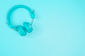 Image showing Pastel green headphone on pastel green metal table background.