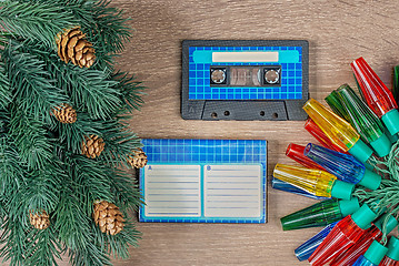 Image showing Retro blue audio cassette and christmas decorations on bown wooden background.