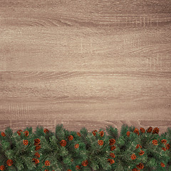 Image showing Evergreen fir branches on brown wooden texture background.