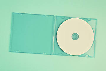 Image showing White cd in transparent case on pastel green background.