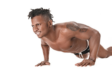 Image showing Muscular young man doing press-ups