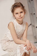 Image showing Little pretty girl with flowers dressed in wedding dresses