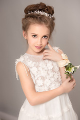 Image showing Little pretty girl with flowers dressed in wedding dresses