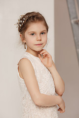 Image showing Little pretty girl with flowers dressed in wedding dresses