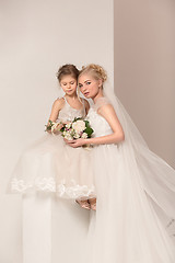 Image showing Little pretty girls with flowers dressed in wedding dresses