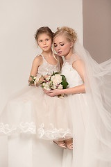 Image showing Little pretty girls with flowers dressed in wedding dresses