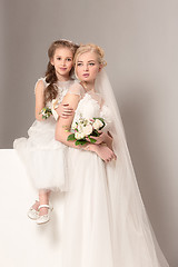 Image showing Little pretty girls with flowers dressed in wedding dresses