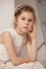 Image showing Little pretty girl with flowers dressed in wedding dresses