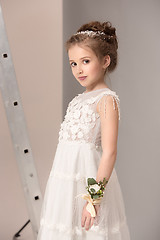 Image showing Little pretty girl with flowers dressed in wedding dresses