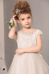 Image showing Little pretty girl with flowers dressed in wedding dresses