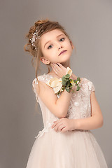 Image showing Little pretty girl with flowers dressed in wedding dresses