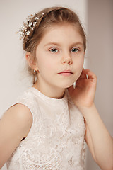 Image showing Little pretty girl with flowers dressed in wedding dresses