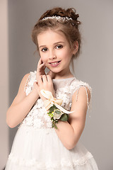 Image showing Little pretty girl with flowers dressed in wedding dresses