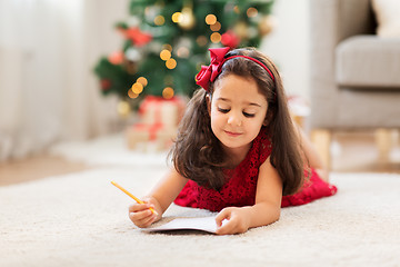 Image showing little girl writing christmas wish list at home