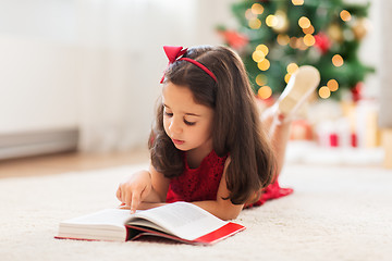 Image showing happy girl reading book at home on christmas