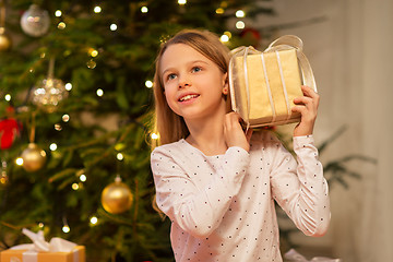 Image showing smiling girl with christmas gift at home