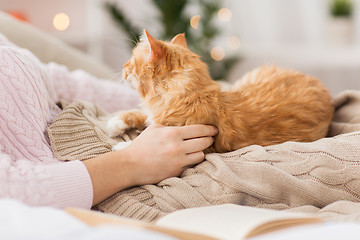 Image showing close up of owner with red cat in bed at home