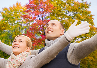 Image showing happy couple spreading hands leaves in autumn park