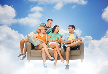 Image showing friends sitting on sofa over background