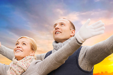 Image showing happy couple in autumn clothes over sunset in city