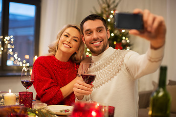 Image showing happy couple taking selfie at christmas dinner