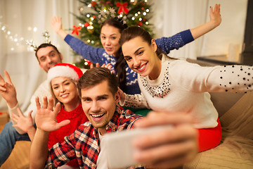 Image showing friends celebrating christmas and taking selfie