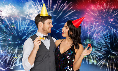 Image showing happy couple with party blowers having fun