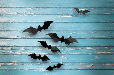 Image showing black bats over blue shabby boards background