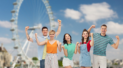 Image showing happy friends making fist pump over ferry wheel