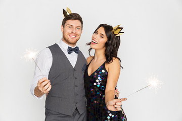 Image showing happy couple with crowns and sparklers at party