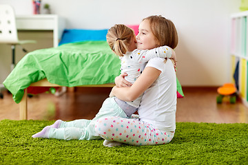 Image showing happy little girls or sisters hugging at home