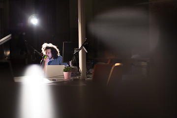 Image showing man working on computer in dark office