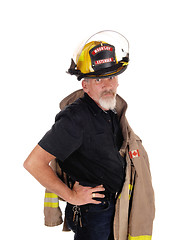 Image showing A firefighter standing with his helmet on 