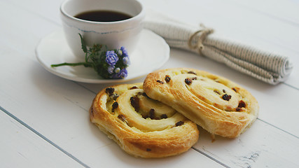 Image showing Delicious pastry with raisins and a cup of coffee top view.